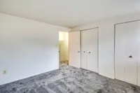 Bright Meadows Townhomes bedroom showcasing two closets and a plush carpeted floor for comfort.