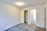 A vacant room featuring a closet and a door, showcasing the simplicity of Allyson Gardens Apartments II.
