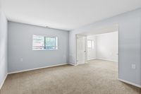 Bright, spacious room featuring soft carpet flooring and large windows with abundant natural light.