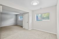 Bright and inviting empty room with plush carpet and large windows, perfect for customization in a modern apartment.