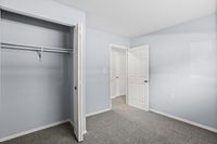 Bright and spacious bedroom with a large closet and fresh modern design, perfect for comfortable living.