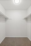 Spacious walk-in closet with ample hanging space and modern lighting.