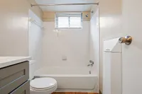 Bright and modern bathroom featuring a sleek white bathtub, stylish tile walls, and natural light from a window above.