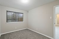 Cozy room with modern carpet flooring, bright window with blinds, and soft neutral wall tones.