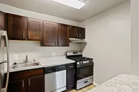 Modern kitchen featuring elegant dark wood cabinets, sleek stainless steel appliances, and a spacious marble countertop.