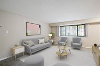 Modern and inviting living room with stylish gray furniture, large window for natural light, and contemporary art piece.
