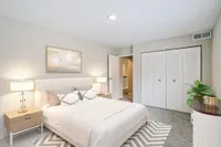 Elegant bedroom with a cozy bed, modern nightstands, and stylish decor, offering a peaceful retreat with abundant natural light.