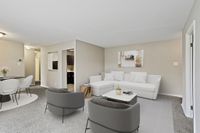 Contemporary open-plan living room with elegant seating, modern decor, and a cozy dining area.
