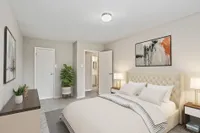 Inviting bedroom with elegant decor, featuring a plush upholstered bed, stylish artwork, and soft neutral tones.