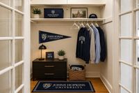 Chic entryway adorned with Johns Hopkins University decor, featuring a cozy closet space, elegant shelving, and stylish hanging attire.