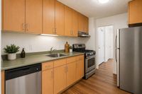 Modern kitchen boasting sleek stainless steel appliances, elegant wooden cabinets, and warm hardwood flooring, perfect for culinary creativity.