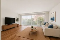 Bright and spacious living room with large windows, modern decor, and a comfortable seating area, perfect for relaxation and entertainment.