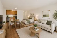 Chic open-concept studio apartment featuring a cozy bed, modern kitchenette, elegant dining area, and stylish living space with natural decor.