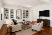 Bright and inviting living room with elegant furniture, hardwood floors, built-in shelves, and a stylish mirror.