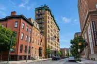 Charming urban street with beautifully preserved historic architecture and a vibrant city backdrop.