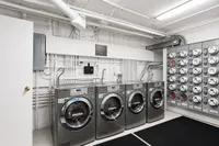 Modern laundry room equipped with stainless steel washing machines and an organized utility panel, offering convenience and efficiency.