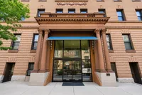 Elegant brick building entrance with classic architectural columns and a blue canopy at 701 The Severn.