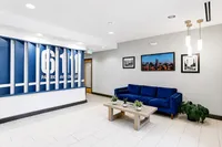 Modern apartment lobby featuring elegant decor, a vibrant blue sofa, and chic wall art at 6111 Park Avenue.