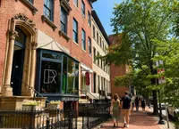 Charming street view of classic row houses with ornate architecture and vibrant storefronts, exuding urban charm and inviting pedestrian appeal.