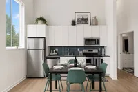 Bright modern kitchen featuring sleek cabinetry, stainless steel appliances, and a cozy dining area with a scenic window view.