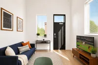 Chic and modern living room with a cozy blue sofa, stylish artwork, natural light, and a sleek TV setup.
