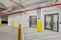 Modern parking garage with sleek elevator access and vibrant yellow accents, offering convenience and style.