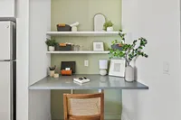 Charming home office nook with sleek desk, stylish shelving, and vibrant green accents, thoughtfully designed for productivity and style.