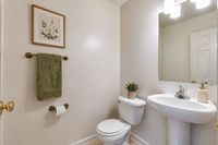 Charming, well-lit bathroom featuring a sleek pedestal sink, elegant wall art, and modern fixtures.