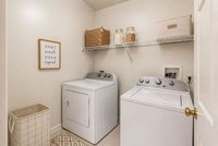 Chic laundry room with modern washer and dryer, stylish storage solutions, and elegant decor for organized living.