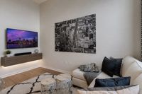 Chic modern living room featuring a sleek wall-mounted TV, elegant artwork, and cozy seating area with stylish decor.