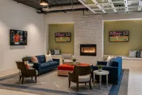 Stylish living room with cozy fireplace, plush seating, and multiple TVs, perfect for relaxing and entertainment.