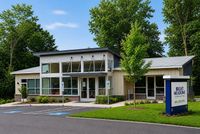 Bright Meadows Leasing Office with modern design, large windows, and lush landscaping in a tranquil setting.