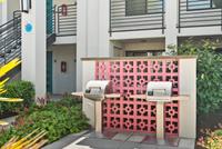 Charming apartment complex with stylish outdoor BBQ area, accented by a vibrant pink decorative wall and lush greenery. Charming apartment complex with stylish outdoor BBQ area, accented by a vibrant pink decorative wall and lush greenery.