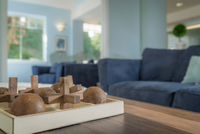 Inviting living room with plush blue sofas and a modern wooden centerpiece, filled with natural light from large windows and elegant decor.
