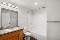 Modern bathroom with vanity storage and full shower-tub setup.