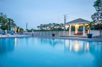 Tradition at Palm Aire 1-Bedroom Apartments In Sarasota, FL - Tradition at Palm Aire - Resort-Stye Pool With Sundeck, Cabana, Lounge Chairs, And Umbrellas.