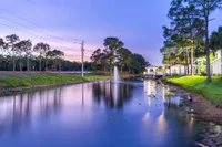 Tradition at Palm Aire exterior lake with fountain and apartment building
