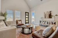 Furnished living room with windows, door to patio, couch, rug and sitting chairs