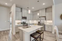 Kitchen with light grey cabinets and stainless steel applicances with kitchen island