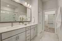 Bathroom with double vanity and large mirror with view of the closet