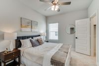 Furnished guest bedroom with ceiling fan and carpet