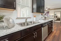 Modern kitchen with granite countertops, stainless steel sink, and elegant cabinetry.