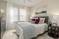 Bright and cozy bedroom with neutral tones, featuring lush bedding and modern decor.
