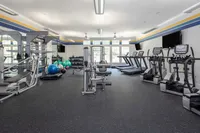 Modern gym with weight machines, treadmills, and exercise balls in a bright, spacious room.