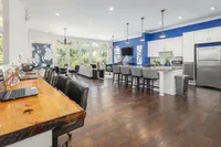 Bright and stylish open-concept entertaining kitchen with modern kitchen, bar seating, and large windows.