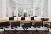 Sophisticated co-working area with a natural wood counter, laptops, and elegant decor.