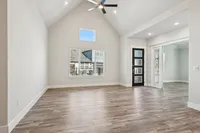 Spacious living area with vaulted ceiling and and french door opening