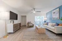 Tradition at Palm Aire Living room with couch, table and exit to balcony