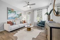 Living room with couch, coffee table and door to attached balcony/patio