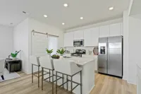 Furnished kitchen with white cabinets and barn door